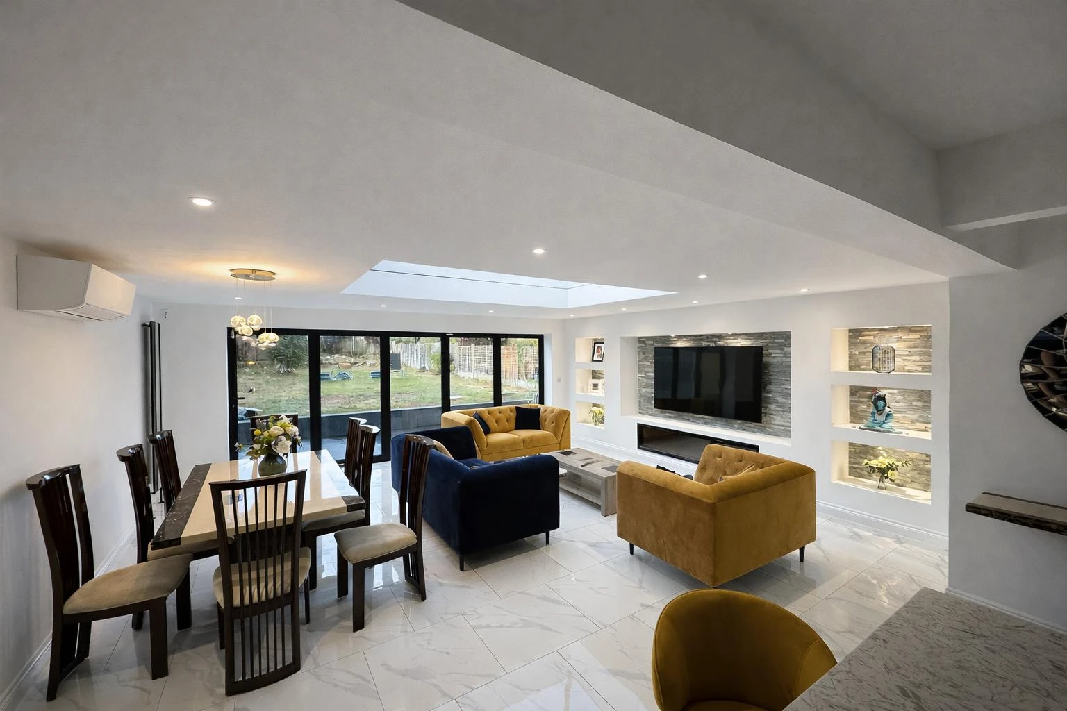 Modern living area featuring a dining table, plush seating, TV, and large windows with natural light. Bright and stylish design.